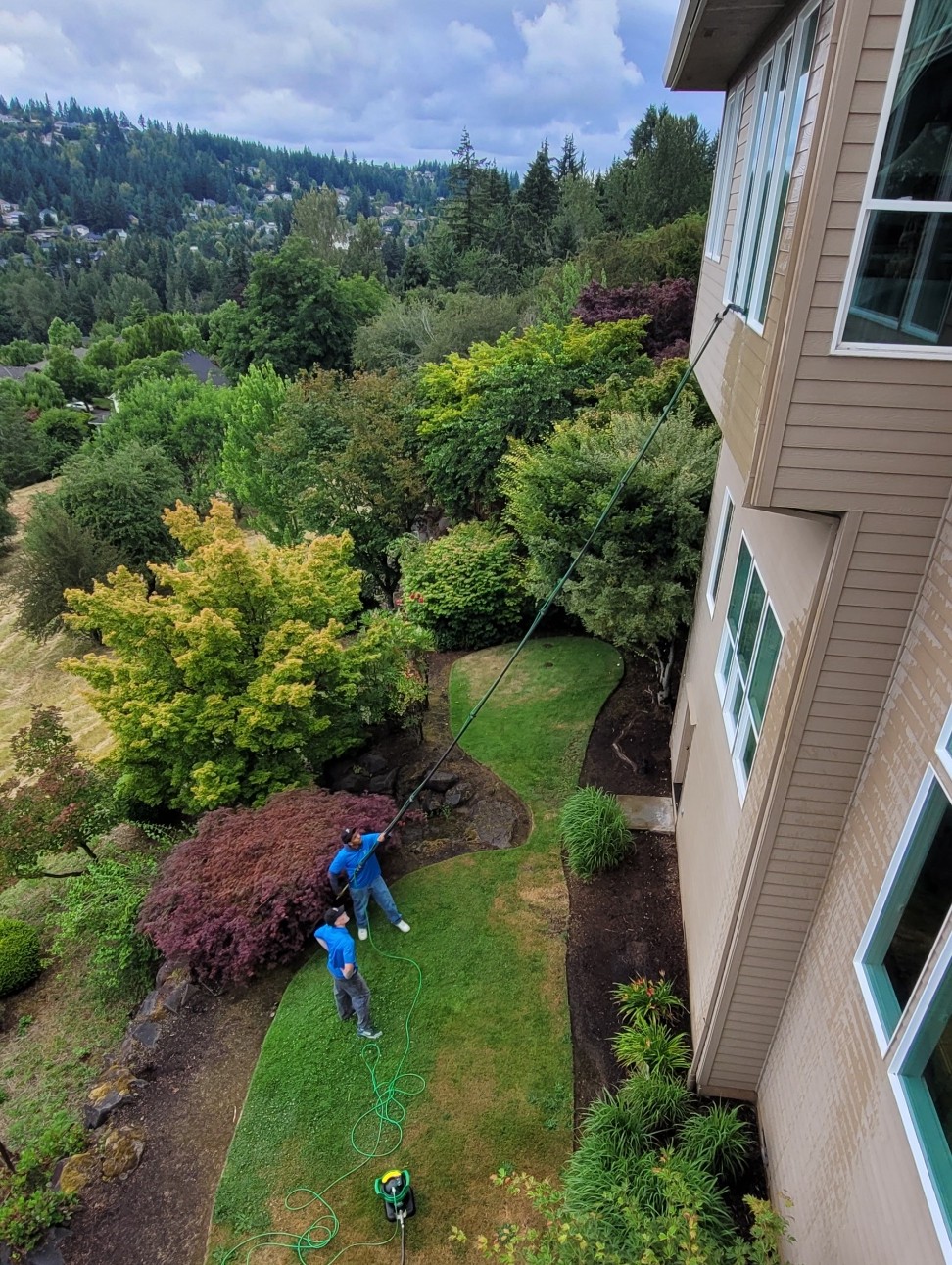 DNA Windows team cleaning second-story windows with a water-fed pole